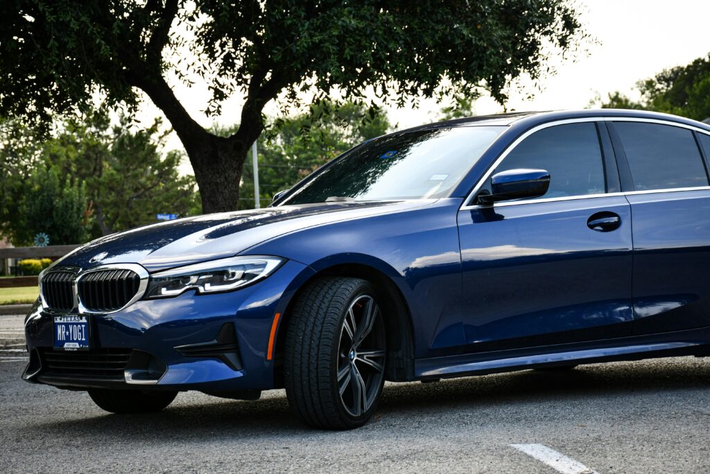 Blue sedan parked outdoors on a summer day in Arlington, Texas, showcasing luxury design and style.